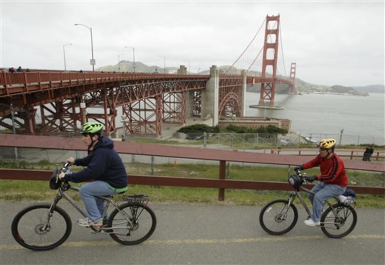 A pair of bicyclists make their way up to the Golden Gate Bridge on April 22 in San Francisco. Officials who oversee the bridge want cyclists to slow down to 5 mph near the Golden Gate's steel towers or face a $100 ticket. 